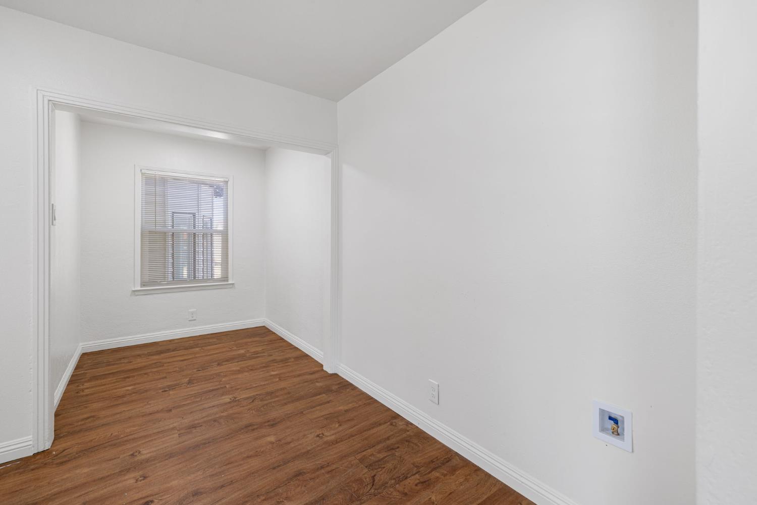 210 East Bush Street Lemoore, CA 93245 - Photo 13 of 42 a view of an empty room with wooden floor and a window