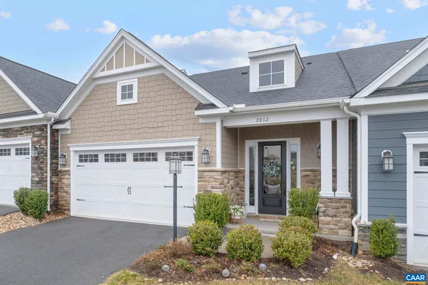 a dining room with stainless steel appliances kitchen island granite countertop a dining table chairs and a refrigerator
