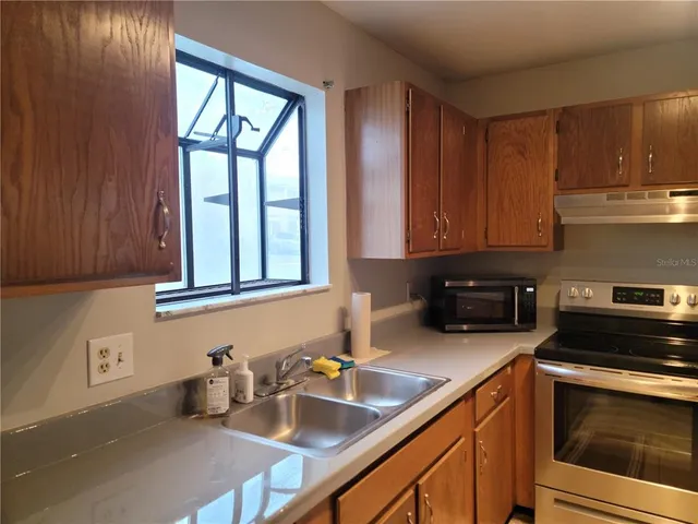 a kitchen with a sink stove and cabinets