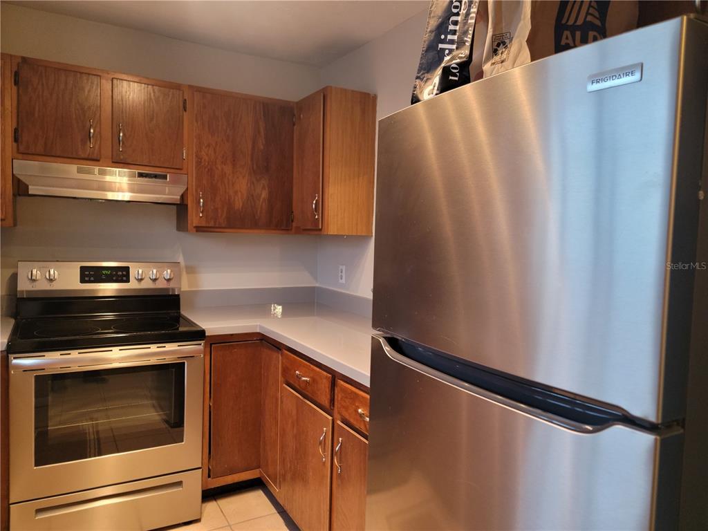 2300 Southwest 43rd Street, Unit I1 Gainesville, FL 32607 - Photo 4 of 15 a kitchen with granite countertop a refrigerator stove and cabinets