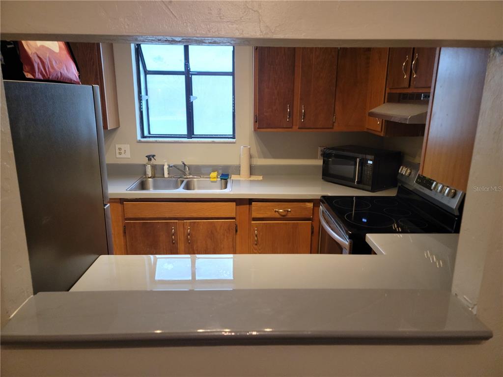 2300 Southwest 43rd Street, Unit I1 Gainesville, FL 32607 - Photo 9 of 15 a kitchen with stainless steel appliances a sink a stove a refrigerator a sink a counter and cabinets