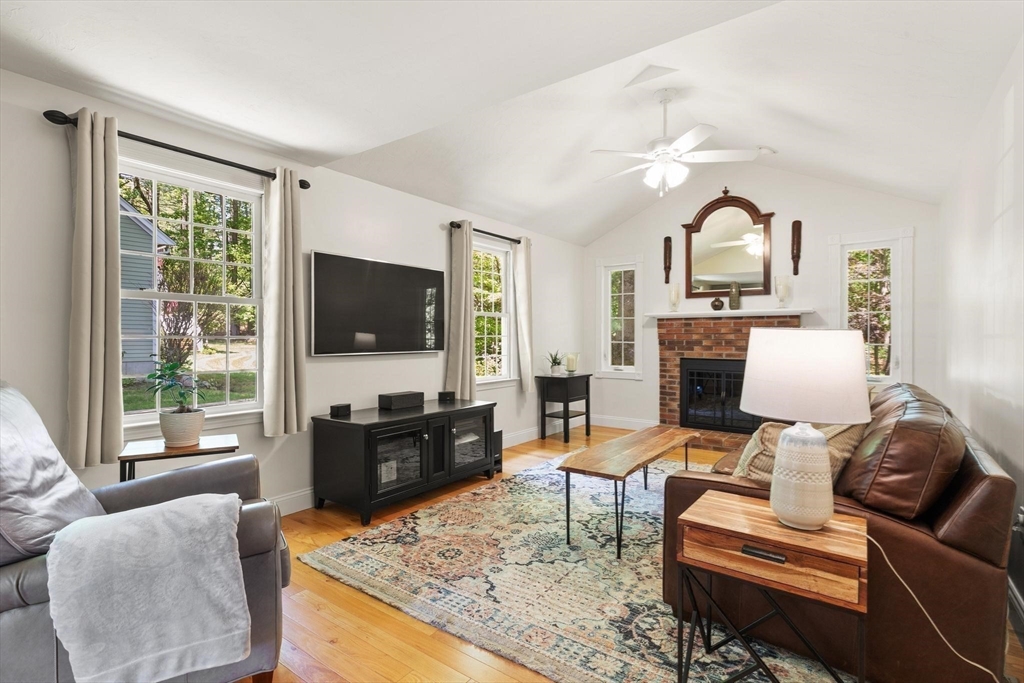 67 Bridle Path Franklin, MA 02038 - Photo 10 of 35 a living room with furniture a flat screen tv and a chandelier