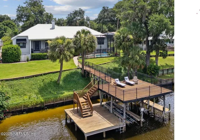 a view of a house with pool and chairs