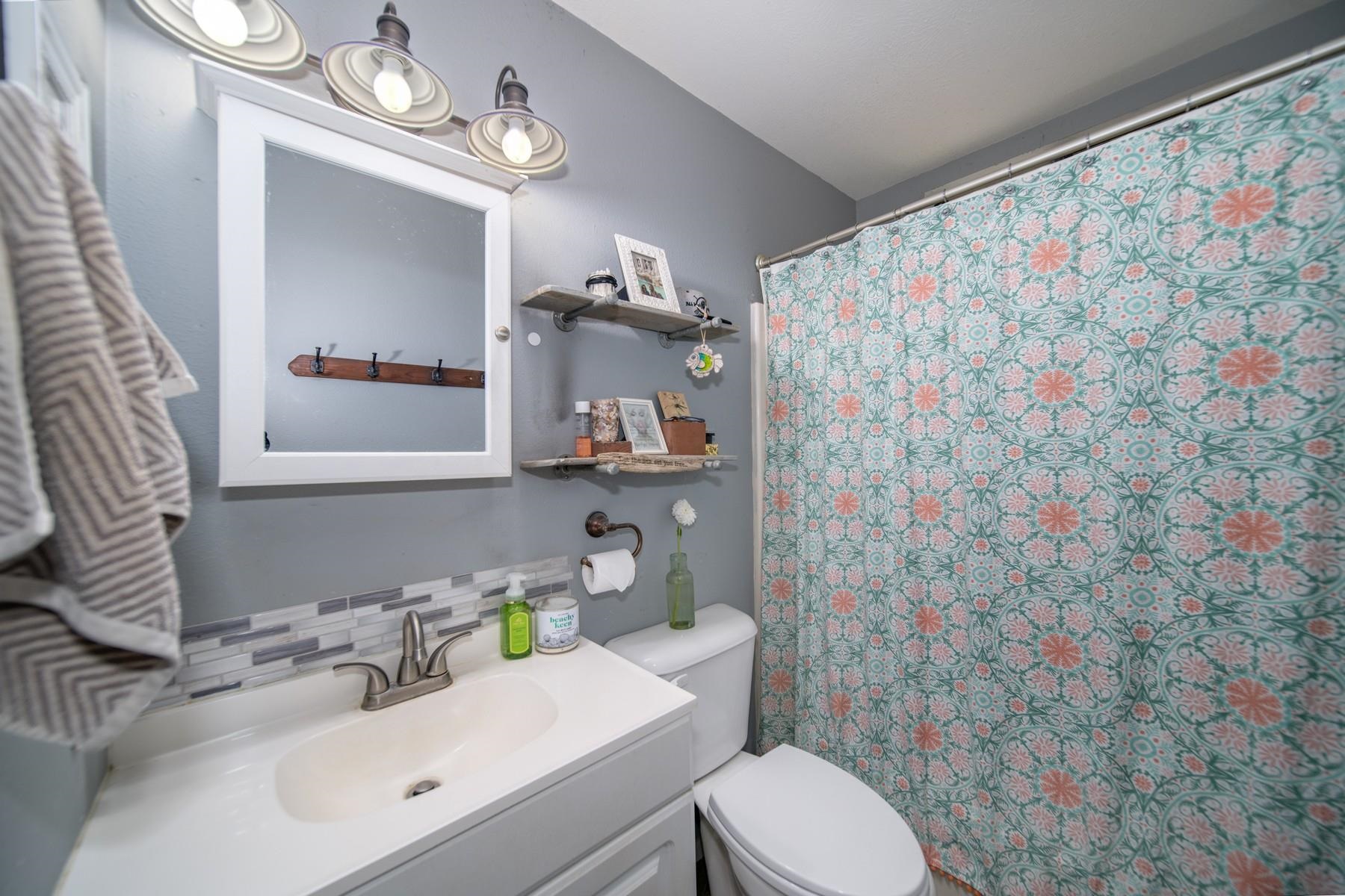 1632 Haiku Road Haiku, HI 96708 - Photo 24 of 27 a bathroom with a sink a toilet and shower curtain