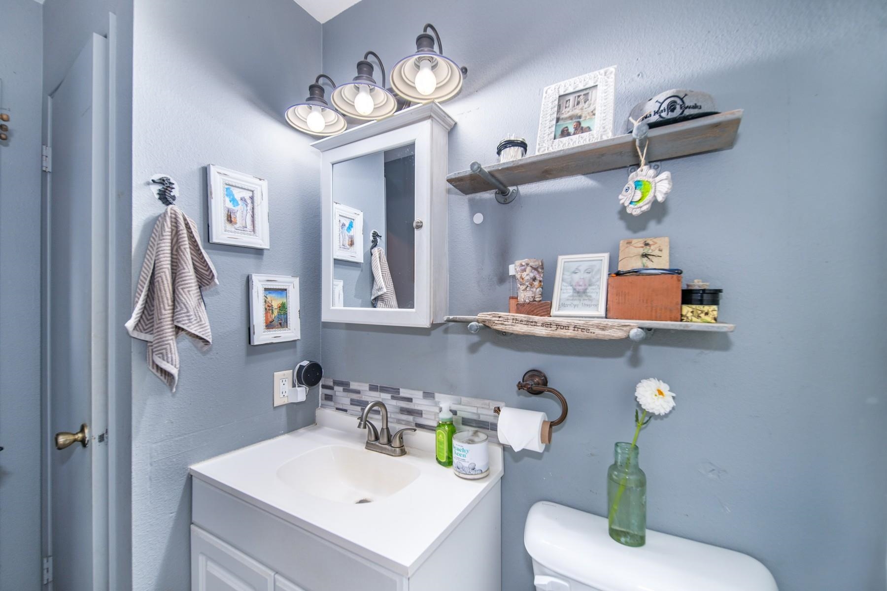 1632 Haiku Road Haiku, HI 96708 - Photo 25 of 27 a bathroom with a sink vanity mirror and toilet