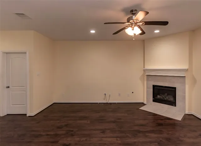 a view of a livingroom with wooden floor and a fireplace