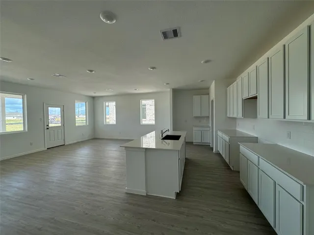 a kitchen with a refrigerator a sink and white cabinets