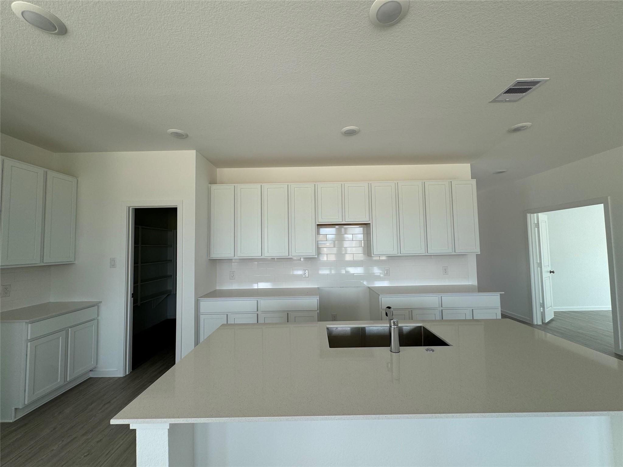 8306 Opal Pond Drive Angleton, TX 77515 - Photo 5 of 18 a kitchen with a refrigerator a sink and white cabinets