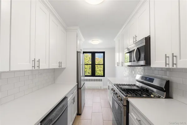 a kitchen with stainless steel appliances a sink dishwasher stove and oven with cabinets