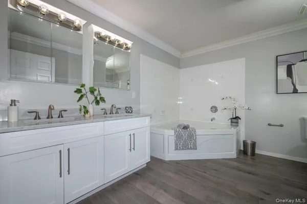 a spacious bathroom with a granite countertop sink mirror and bathtub