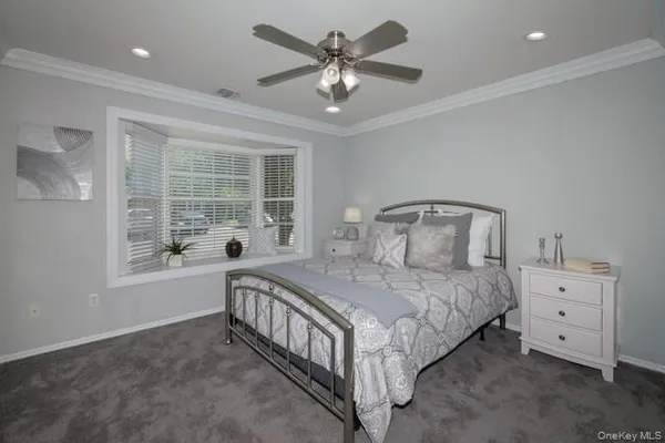 a bedroom with a bed a window and a chandelier