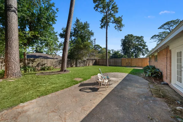 a view of a park with a bench in front of house