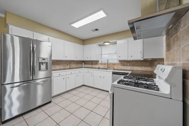 a kitchen with cabinets stainless steel appliances and a counter space