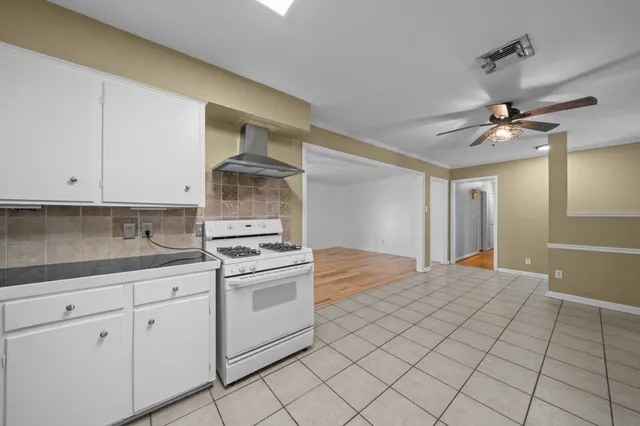 a kitchen with granite countertop white cabinets and white appliances