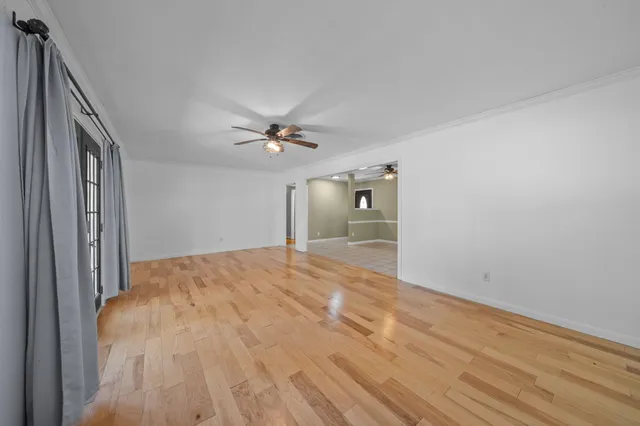 a view of empty room with wooden floor