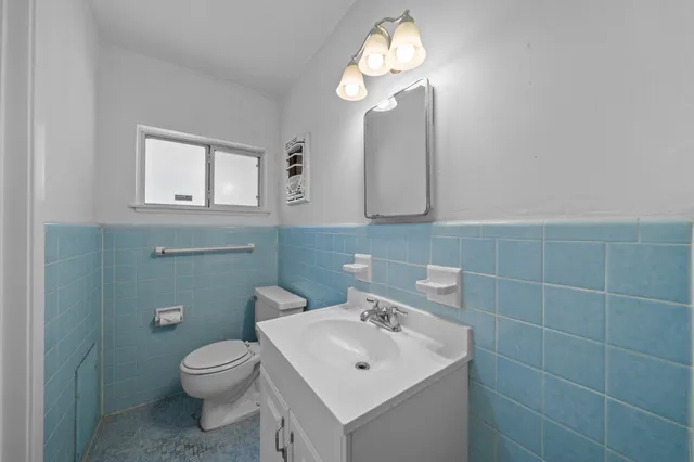 a bathroom with a toilet sink and mirror