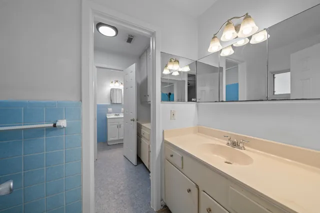 a spacious bathroom with a sink a large mirror and a shower