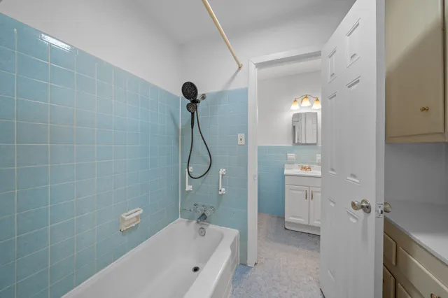 a bathroom with a bathtub a mirror a shower and vanity