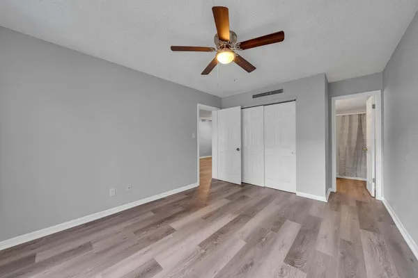 a view of room with wooden floor and ceiling fan