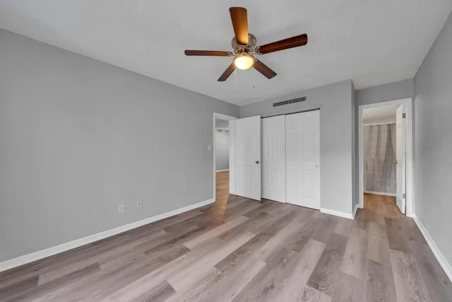 a view of room with wooden floor and ceiling fan
