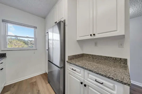 a kitchen with granite countertop cabinets and refrigerator