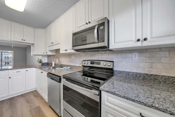a kitchen with cabinets stainless steel appliances and a sink