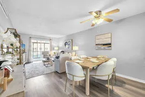a dining room with furniture a livingroom view and wooden floor