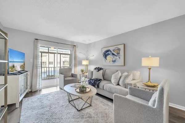 a living room with furniture and a kitchen area