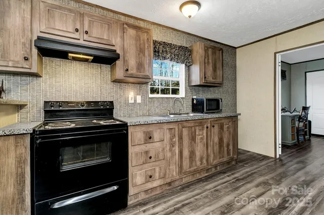 a kitchen with granite countertop a stove sink and cabinets