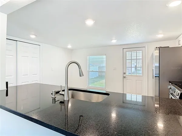 a view of a kitchen with a sink and refrigerator