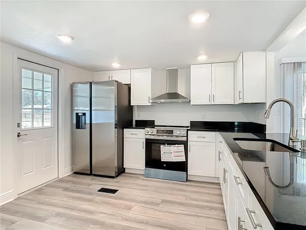 a kitchen with stainless steel appliances granite countertop a refrigerator sink and stove