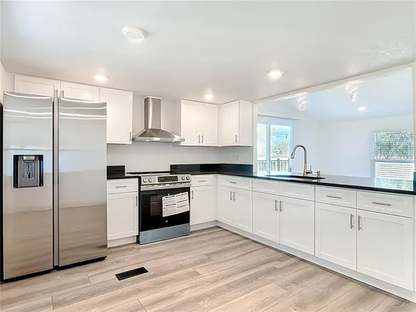 a kitchen with stainless steel appliances granite countertop a stove a sink and a refrigerator