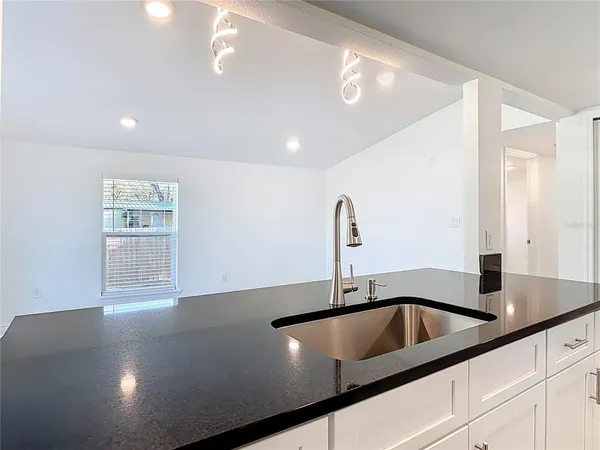 a kitchen with a sink and white cabinets