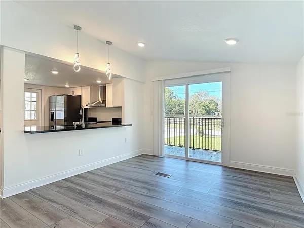 a view of a kitchen with wooden floor and a window