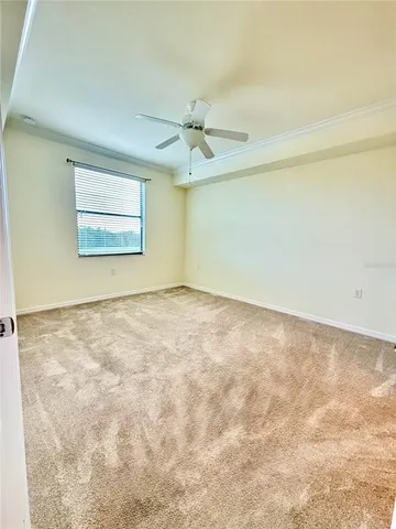an empty room with a window and a ceiling fan