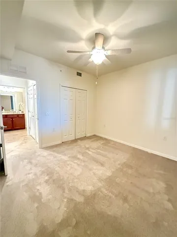 an empty room with a ceiling fan and a window