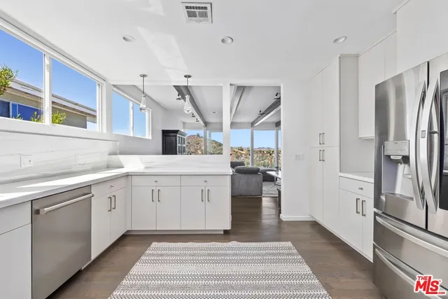 a kitchen with a refrigerator and white cabinets