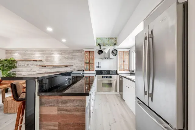 a kitchen with stainless steel appliances a stove a sink and a refrigerator