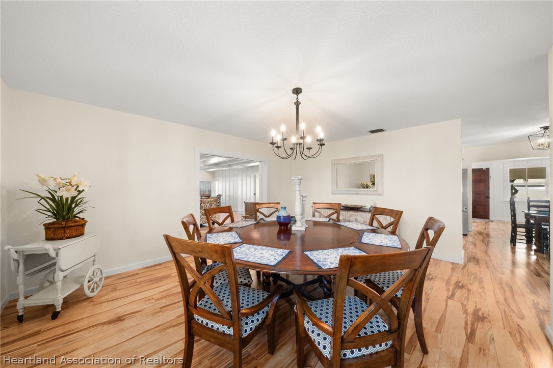 1843 South Lake Reedy Boulevard Frostproof, FL 33843 - Photo 26 of 50 a view of a dining room with furniture a chandelier and wooden floor