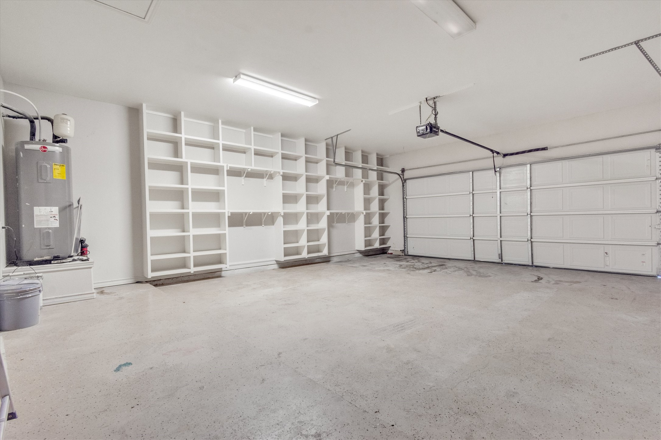 164 Peck Street Kyle, TX 78640 - Photo 17 of 19 Garage with water heater and a garage door opener