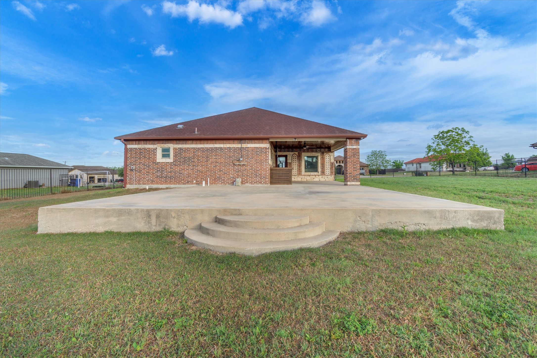 164 Peck Street Kyle, TX 78640 - Photo 18 of 19 Rear view of property with brick siding and a patio area