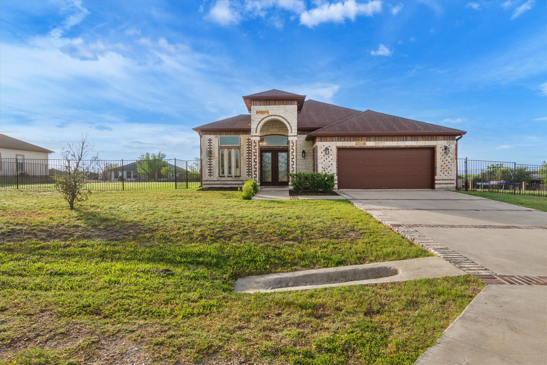 164 Peck Street Kyle, TX 78640 - Photo 2 of 19 Mediterranean / spanish-style house with french doors, brick siding, a garage, and driveway