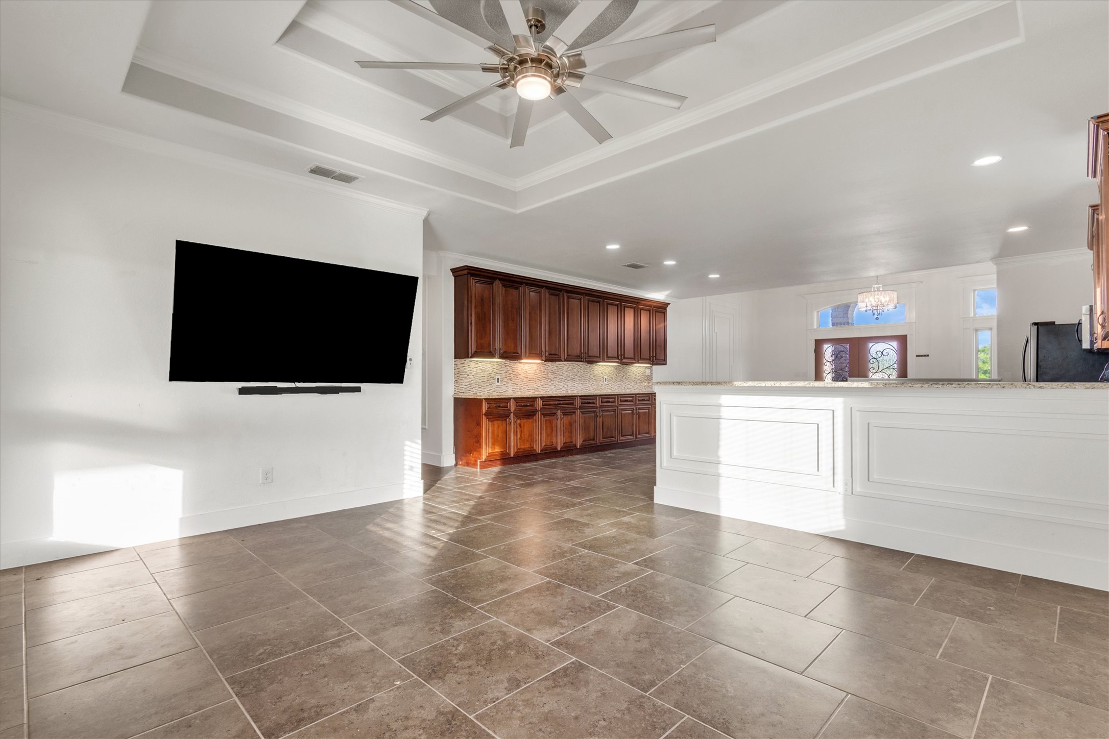 164 Peck Street Kyle, TX 78640 - Photo 7 of 19 Unfurnished living room with a ceiling fan, crown molding, recessed lighting, and dark tile patterned floors