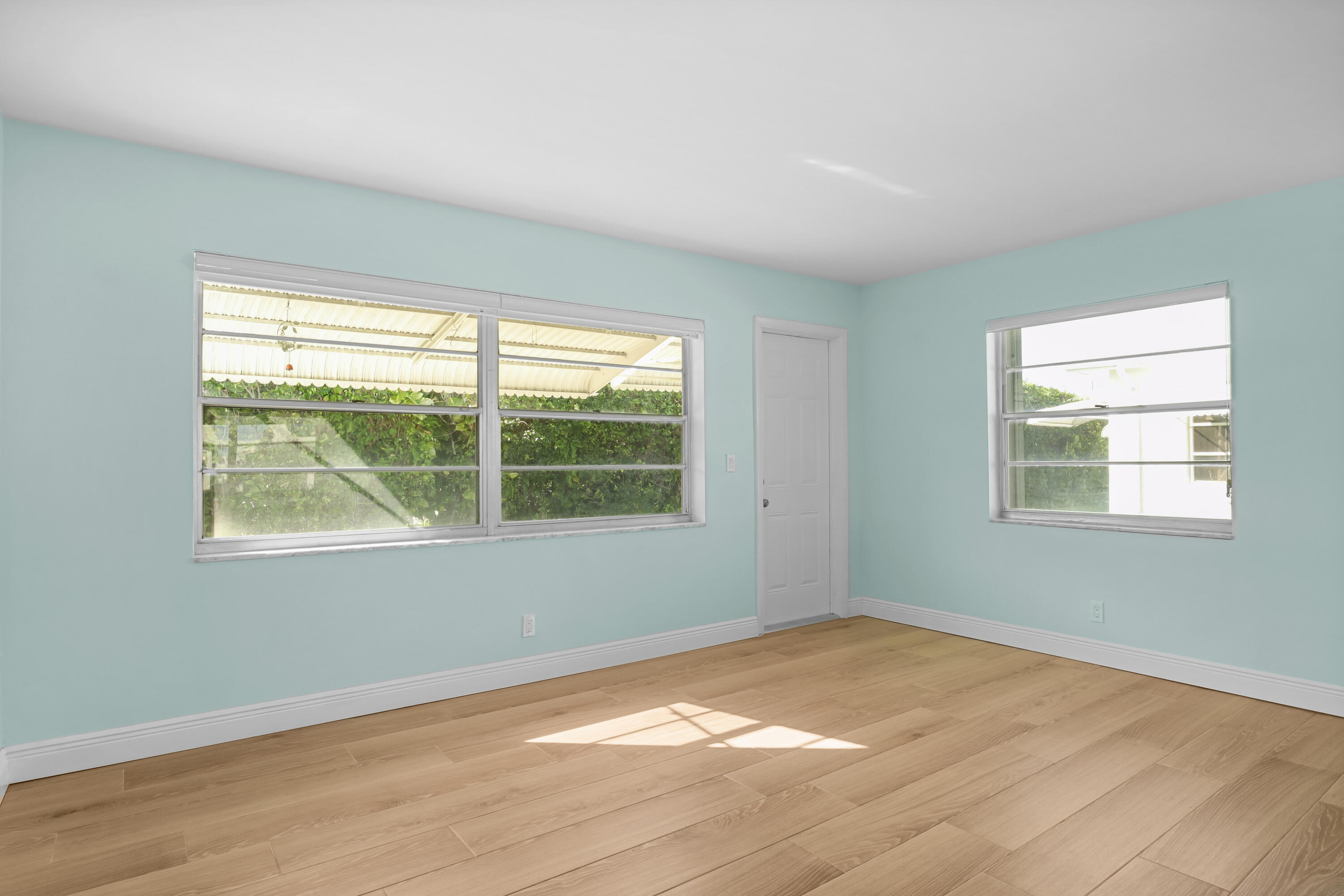 1308 Southwest 24th Street Boynton Beach, FL 33426 - Photo 12 of 19 a view of an empty room with wooden floor and a window