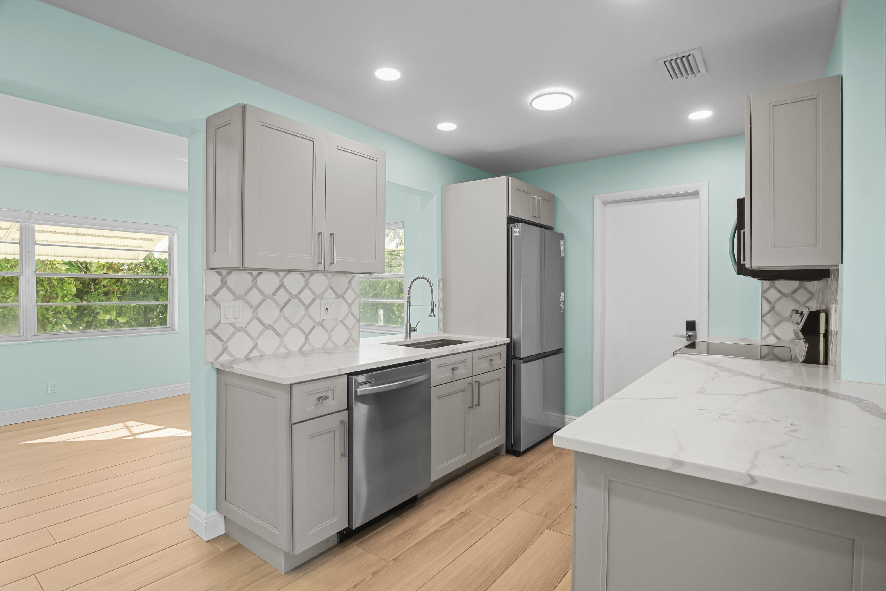 1308 Southwest 24th Street Boynton Beach, FL 33426 - Photo 8 of 19 a kitchen with a sink a refrigerator and a stove top oven