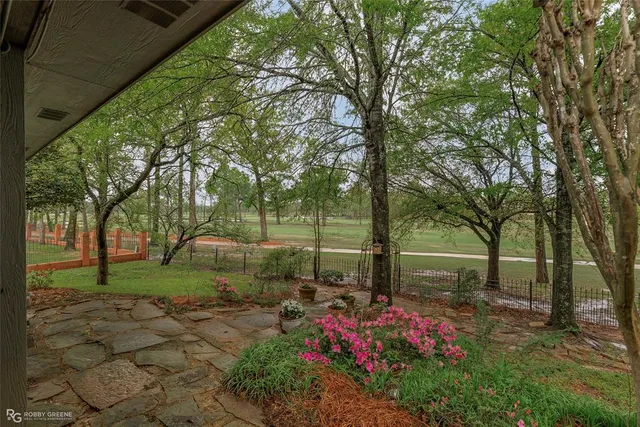 a backyard of a house with lots of green space and fountain