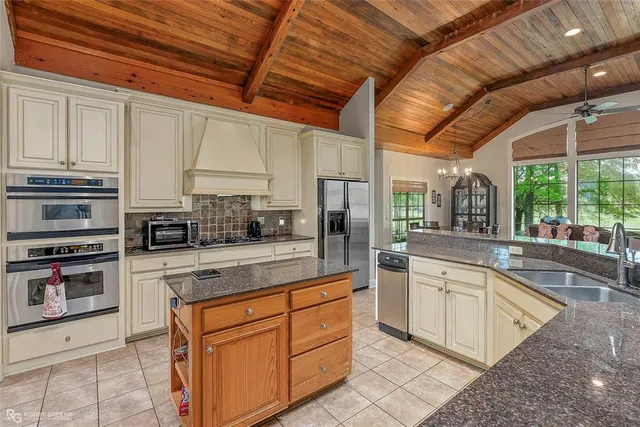 a kitchen with stainless steel appliances granite countertop a stove sink and cabinets