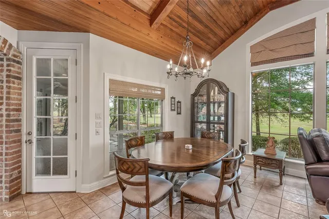 a dining room with furniture large windows and a chandelier
