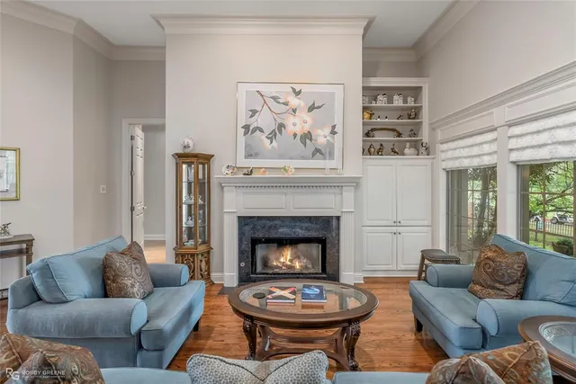 a living room with furniture a fireplace and a large window