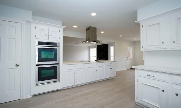 a kitchen with white cabinets and stainless steel appliances